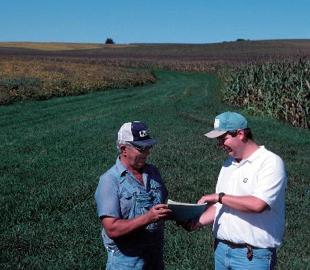 photo of farmer and advisor reviewing conservation plan