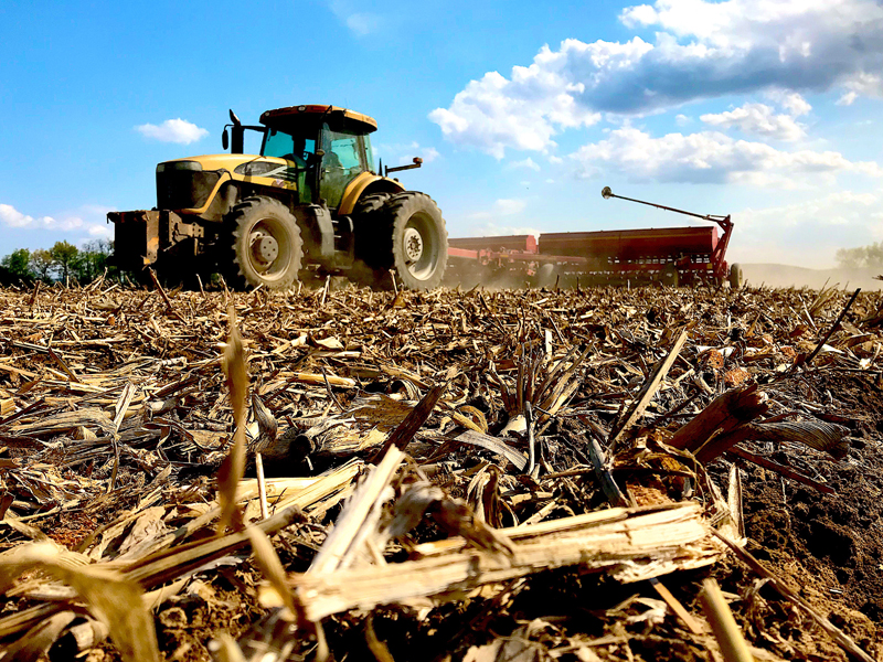 tractor and planter on corn residue in field.