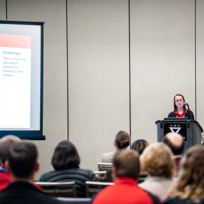 Student presenting in a conference room