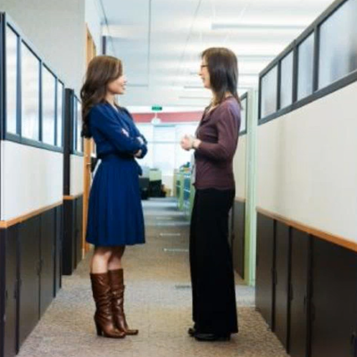 two women talking at work in a hallway