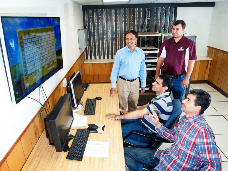 Group of men looking at large screen