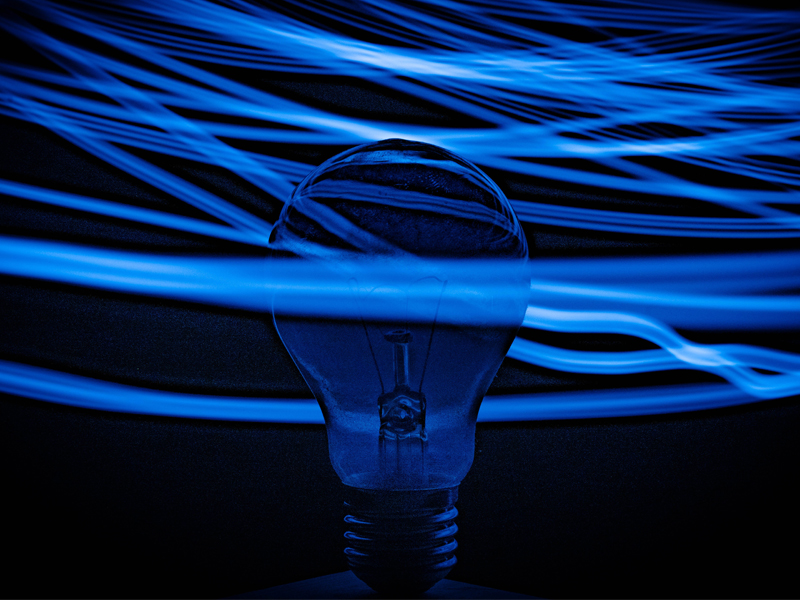 blue lightbulb in front of dark background